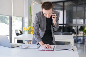 Naklejka premium Handsome confident asian secretary man clever smart professional businessman &nbsp;talking on phone&nbsp;&nbsp;in office