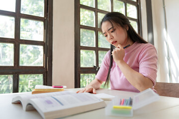 Asian girl student doing exam hand holding pencil writing answer in university classroom education high school or university student taking notes while preparing for exam