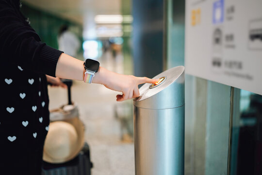 A Traveler Preparing to Use a Lift Button in an Airport