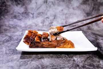 pick up with a piece of grilled duck from a plate