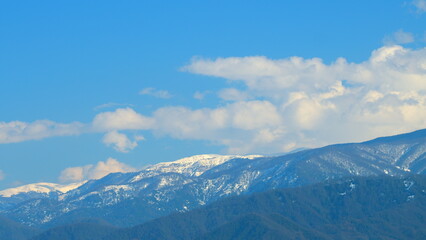 Blue Sky And Fluffy White Clouds. Mountain Landscape. Blue Mountain Chain In Snow. Timelapse.