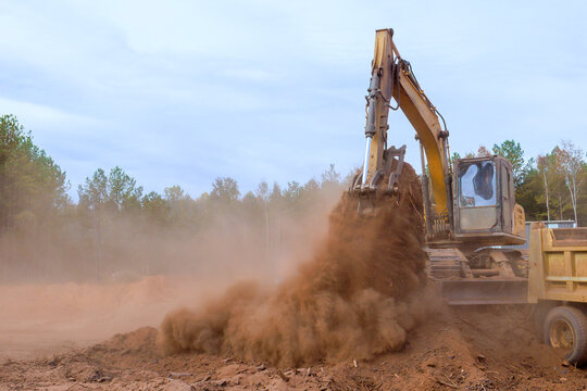 Loading earth into dump truck with assistance of an excavator