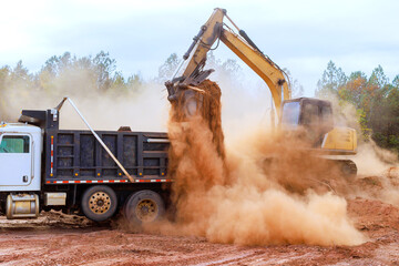 Excavator is used to load earth into dump truck at construction site