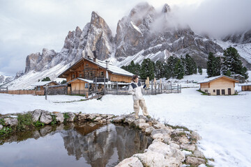 Woman enjoy the view of Geisler Alm, Adolf Munkel Trail, Nature Park, Dolomites Italy.