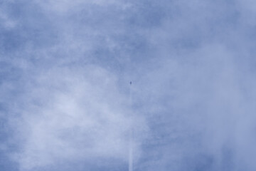 Airplane with white cloud on light blue sky in summer.