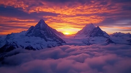 Naklejka premium Majestic snow-capped mountain peaks with a fiery sunset sky and clouds