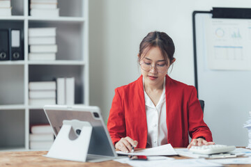Focused on Success: A driven businesswoman meticulously analyzing data and financial reports,...