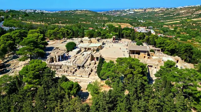 The ancient Knossos Palace ruins in Crete, Greece surrounded by lush trees and rolling hills