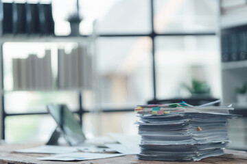 Overwhelmed: A Stack of Papers in a Busy Office - A close-up shot of a stack of papers on a desk,...