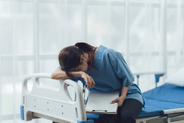 Exhausted Nurse: A compassionate nurse leans heavily on a hospital bed, exhaustion etched on her...