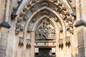 Stone  carved religious scene on the facade of St Vitus Cathedral near New Royal Palace in Prague in Czech Republic