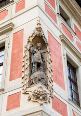 Statue in a niche on the corner of a building of municipality near St Vitus Cathedral in Prague in Czech Republic