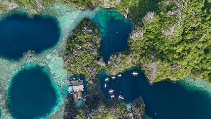 Top View of Turquoise Lagoons and Boats Surrounded by Lush Limestone Cliffs in Coron, Palawan, Philippines