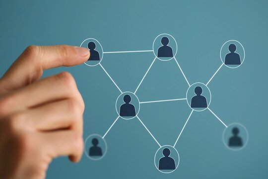 A close-up of a hand interacting with a digital network graphic, symbolizing connection and collaboration in social systems.