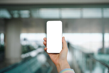 Hand Holding a Smartphone in an Airport Setting