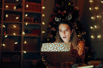 Surprised Woman Opening her Christmas Present at Home. Amazed millennial lady reacting to her Xmas...