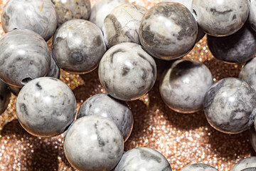 Beautiful round beads of gray jasper in macro photography, perfect for crafting and jewelry design. Decorative round stone beads of gray color  for boho jewelry design.