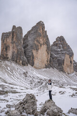 Naklejka premium Woman enjoy view of Tre Cime di Lavaredo in winter. Landscape of Alps Mountains. Dolomites, Italy.