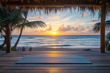 Yoga mat spread out on sunset wooden deck in front of the ocean with palm trees