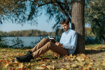 Thoughtful Man Engrossed in a Book in a Scenic Outdoor Setting