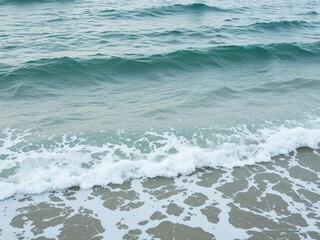 Background of ocean waves gently crashing with sea foam in the foreground, summer, marine