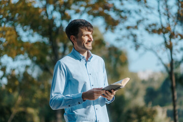 Leisurely Park Walk American Man Reads Book in Calm Outdoor Scene