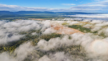 Flying above the clouds at dawn in autumn