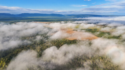 Flying above the clouds at dawn in autumn