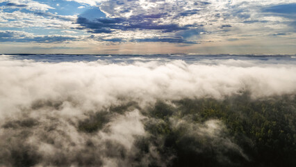 Flying above the clouds at dawn in autumn