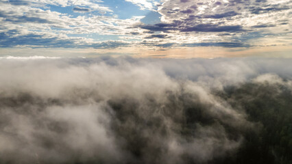 Obraz premium Flying above the clouds at dawn in autumn
