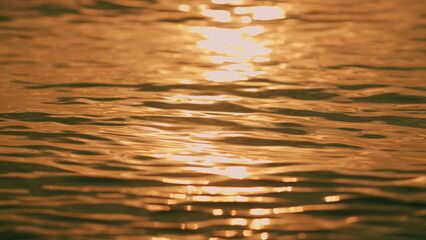 Close up. Reflection Of Sunlight Over Sea Or Ocean. Abstract Smooth Glittering. Sun Glare On Water.