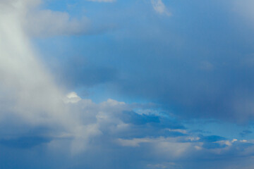 Cumulus clouds. Beautiful dark blue dramatic sky. Copy space for lettering. Few clouds against a blue sky on a sunny day.