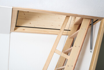Open loft ladder or attic ladder inside. Loft sliding ladder with open hatch or attic door. Used to...