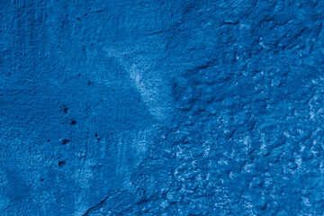 Grunge classic blue concrete background. Textured plaster wall. Creative backdrop for your design. Color of the year 2025 concept. Top view, layout for design. Surface with peeling shabby pattern.