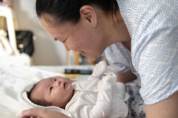 Portrait of a beautiful an Asian mother, with her nursing baby