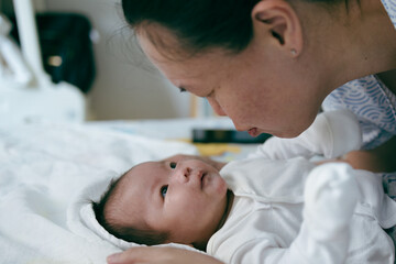 Portrait of a beautiful an Asian mother, with her nursing baby