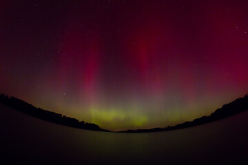 aurora borealis in mid-latitudes, colorful structures visible in the night sky above the lake