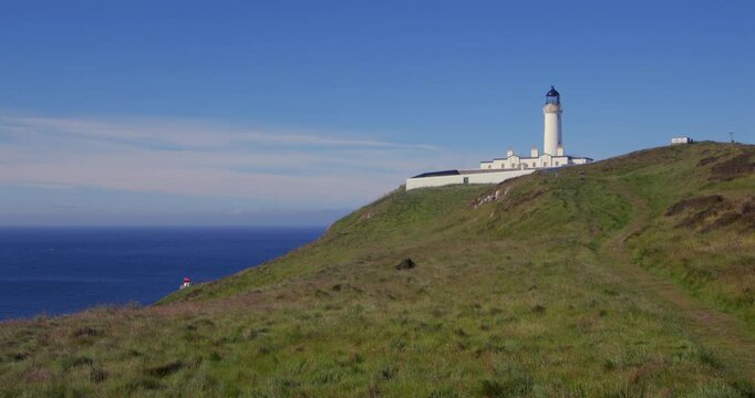 extra wide shot looking West onto the Mull of Galloway lighthouse and foghorn with fields in foreground