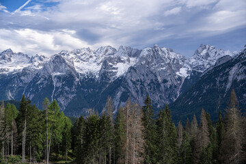 Mountains landscape in winter summits and rocky tower peaks above green valley alpine Dolomites, Italy.