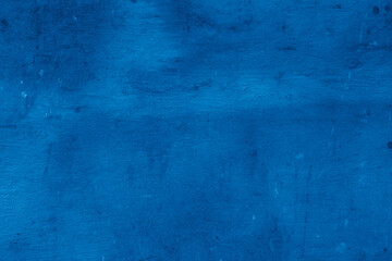Grunge classic blue concrete background. Textured plaster wall. Creative backdrop for your design. Color of the year 2025 concept. Top view, layout for design. Surface with peeling shabby pattern.