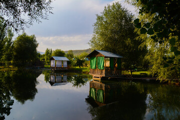 Obraz premium Wooden house by the lake. Cottage on the river bank. Cottage for rest. House in the forest