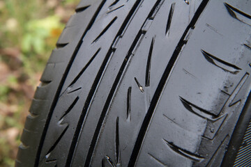 Directional tread of a summer car tire close-up. An old shabby car tire.