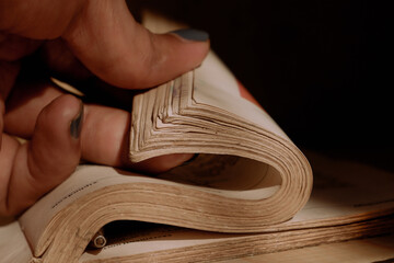 a person's hand holding a thick book