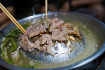 Group friends having party eating Thai style local hot pot in outdoors camping at night