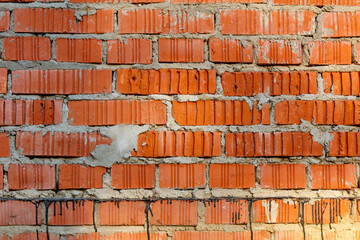 A brick wall with a few holes and some paint on it