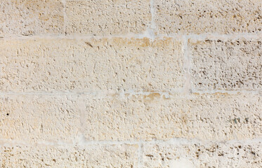 A wall made of white bricks with a rough texture