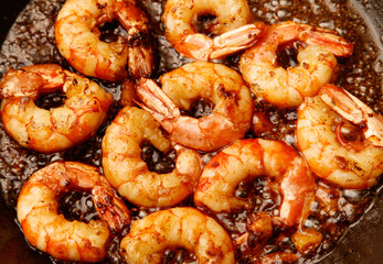 A pan of shrimp is cooking in a skillet