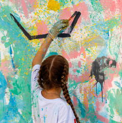 A girl is painting a wall with a brush