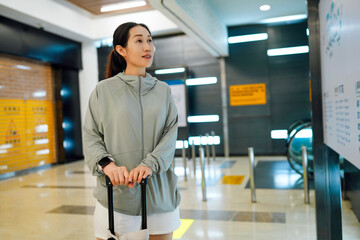 Young Woman with Luggage in Modern Urban Setting