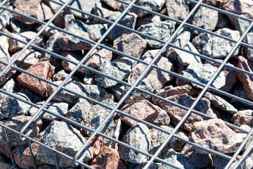 A close up of a rock pile with a metal grid underneath